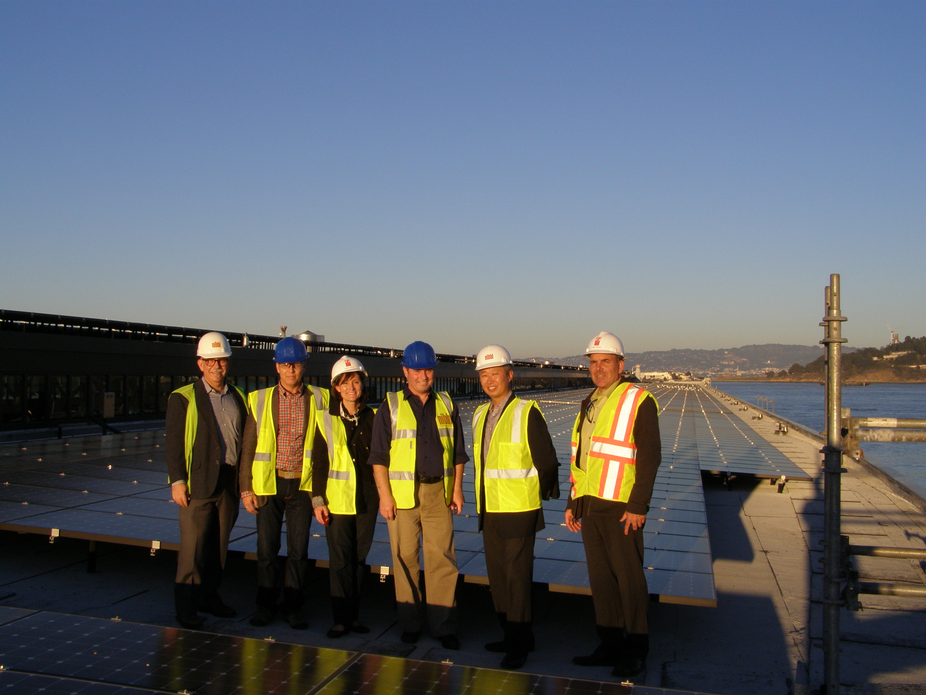 Applicants and federal and state tax credit reviewers inspecting solar panels on roof
